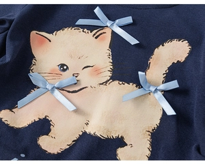 Dettaglio della stampa gatto fatta a mano e fiocchi di raso blu su top in cotone blu notte