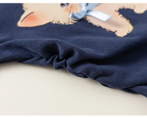Dettaglio maglia blu scuro con motivo a gatto e fiocco in raso azzurro per bambina