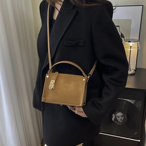 Brown suede box handbag with gold twist lock and metal studs for autumn fashion