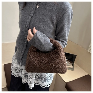 Gros plan sur un sac à main en fausse fourrure peluche marron avec anse minimaliste