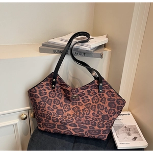 Detailed shot of leopard print tote bag with black straps and golden twist lock closure