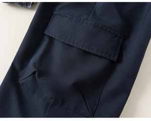 Dettaglio ravvicinato della tasca cargo blu navy su un completo a quadri bimbo