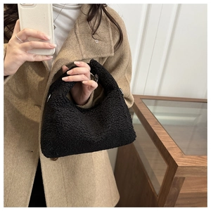 Détail d'un sac à main noir en fausse fourrure avec texture douce en laine d'agneau