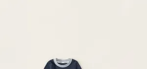 Dettaglio dello scollo della felpa in cotone con bordo blu a contrasto per bambini