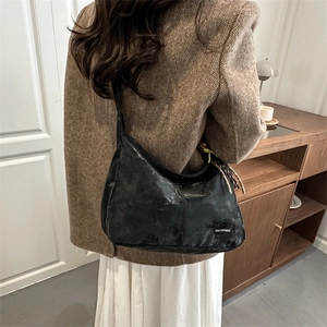 Retro black hobo shoulder bag with Tidal Dryness logo in a minimalist commute style