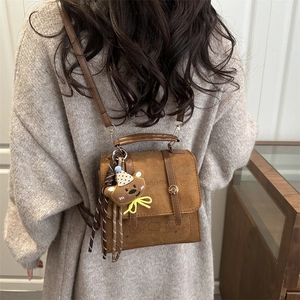 Minimalist brown matte backpack with top handle and cute plush bear charm for women