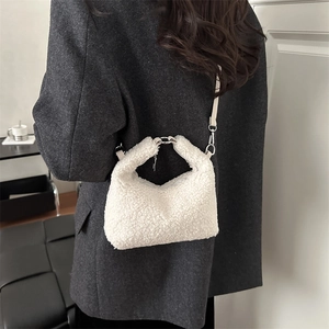 Sac bandoulière en fausse fourrure blanche avec poignée argentée sur modèle en blazer