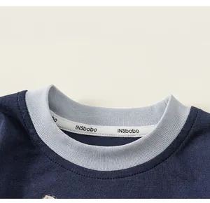 Dettaglio della maglietta in cotone blu navy con colletto a coste azzurro a contrasto