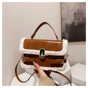 Détail du sac en cuir marron avec bordure en fausse fourrure blanche et boucle dorée