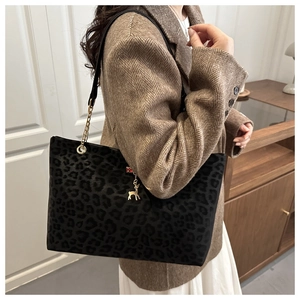 Fashionable leopard print tote bag with gold chain strap shown on person in brown blazer