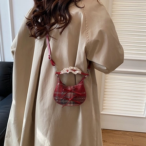 Mini red plaid crossbody bag with bows and lace handle on beige oversize coat