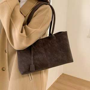 Retro brown suede tote bag with long handles shown on a model in a camel coat