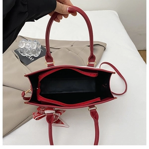 Detail view of red tote bag interior featuring three compartments and a floral scarf handle