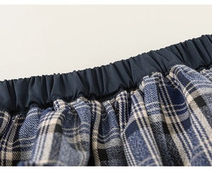 Dettaglio della vita elastica sui pantaloncini di cotone a quadretti blu e bianchi da bambina