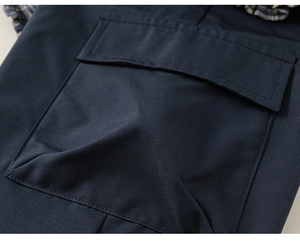 Dettaglio del tessuto in twill blu scuro con tasca a patta e rifiniture a quadretti