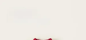 Detail of red knit kids vest with contrast bear pattern and fine craftsmanship