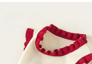 Detailed view of the red ruffled collar and soft knitted texture on this girls' sweater vest