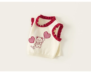Detail of knit vest showing the cute bear embroidery and red ruffled edges