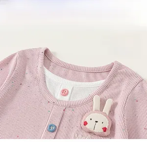 Close-up of pink striped girl's shirt featuring a mock-neck design and rabbit patch