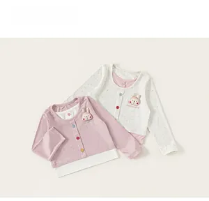 Close-up of the baby long-sleeve tee featuring a rabbit patch and colorful buttons