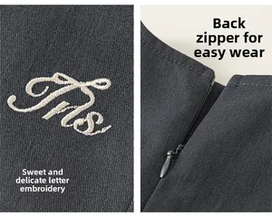 Detail aus Twill-Stoff mit weißer Buchstaben-Stickerei und verdecktem Reißverschluss-Design