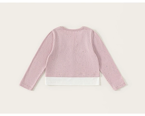 Detail of a pink knit sweater for girls featuring colorful specks and a white hem border