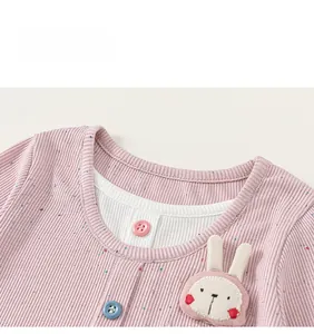 Detail of pink ribbed knit child shirt showing embroidery and fake two-piece collar