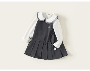 Detailansicht des Schuluniform-Kleides für Mädchen mit Faltenrock und Schleifen-Detail