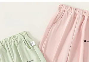Détail de joggings pour enfants vert clair et rose avec taille élastique et poches