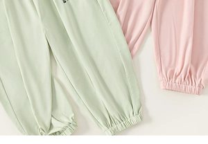 Détail de joggings pour enfants respirants avec chevilles élastiquées en vert et rose
