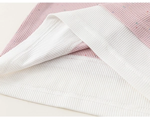 Close-up of pink ribbed knit fabric with colorful speckled details and white trim