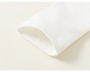 Detail der weißen Baumwoll-Rippbündchen mit präzisen Nähten am langärmeligen Mädchenkleid