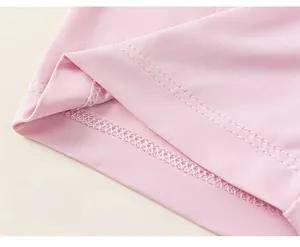 Detail of pink cotton knit fabric showing precise double-needle stitching on the hemline