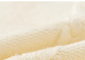 Macro shot of soft cream knit fabric texture on boys collegiate sweater vest