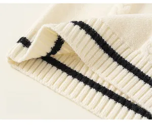 Detailed macro view of the ribbed knit hem with black stripes on an off-white sweater