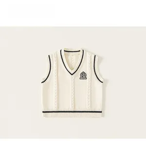 Detail of V-neck knitted vest with contrast stripes and crest embroidery on the chest