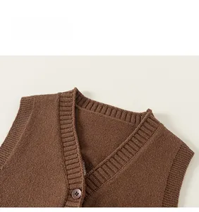 Dettaglio ravvicinato del gilet in maglia marrone con scollo a V e bordo a coste fine