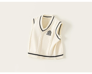 Detail of V-neck knitted kids sweater vest with preppy navy stripes and shield badge