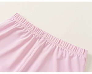 Detail of high-elastic wide waistband on light pink children's trousers with neat stitching