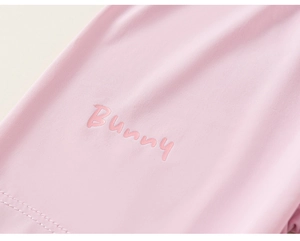 Close-up of pink knit fabric with Bunny letter print and double-needle stitching detail