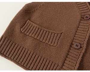 Vista dettagliata del gilet in maglia marrone scuro con texture e bottoni coordinati