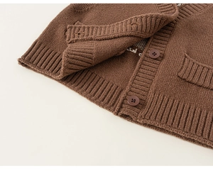 Dettaglio del cardigan in maglia marrone scuro con bordo a coste e bottoni in resina