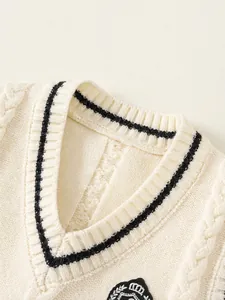 Classic beige boys V-neck cable knit vest with navy striped trim and collegiate embroidery