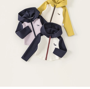 Détails d'un sweat à capuche avec broderie teckel et finitions soignées en coton doux