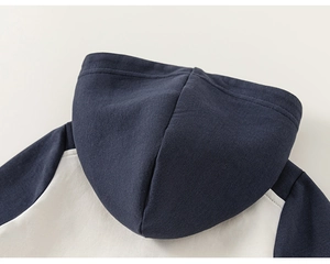 Détail de la veste à capuche bicolore pour filles avec capuche marine et dos crème