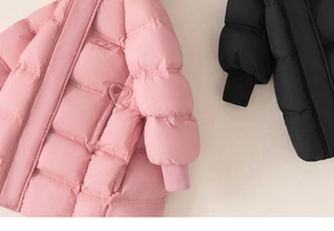 Close-up of heart quilting and letter embroidery on girls' warm winter coats