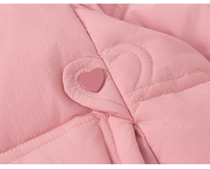 Close-up of pink heart-shaped stitching and decorative button on a girl's down jacket