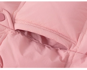 Detail of pink quilted winter jacket showing pocket stitching and windproof fabric texture