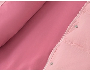 Detail of pink winter coat with white zipper, metal snaps and two-tone fabric textures