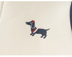 Close-up of children's cream knit hoodie featuring a cute dachshund in a red beret